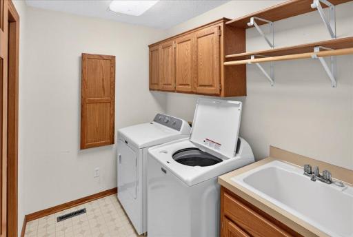 Main level laundry room features a built-in ironing board and utility sink.