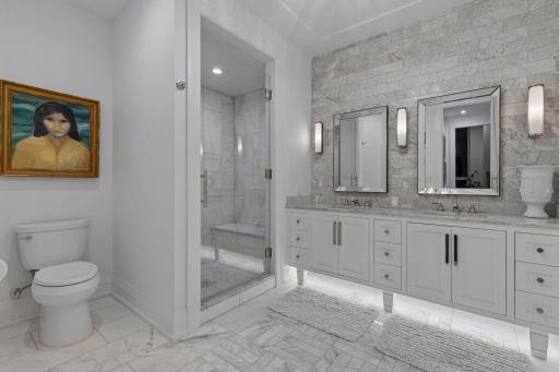 In-floor heat adds an appreciated layer of comfort to the Carrara marble flooring and a full-height Carrara subway-tile vanity backsplash create a cohesive, timeless finish in the owner's bath.