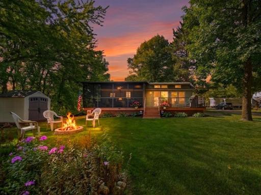 Your ideal evening getaway: relaxing outdoor fire pit, shaded screen porch, and warm home interior at golden hour.