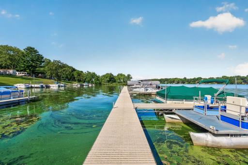 A sturdy dock extends far into the water, providing multiple boat slips, boat lifts, and pontoon docking options.