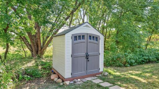 A durable 7x7 outdoor shed sits neatly on the property, offering convenient and secure storage for lawn equipment, tools, and outdoor supplies.