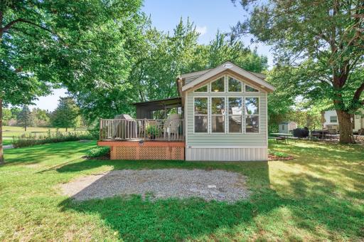 This charming park model home offers a scenic retreat featuring impressive architectural windows and exceptional outdoor living space.