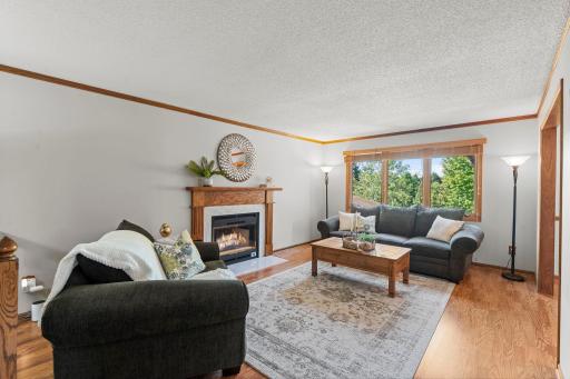 Gather around the wood burning fireplace in this inviting living room filled with natural light and views of the surrounding trees.