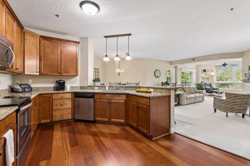 Large kitchen with lots of granite countertop space, cherry cabinetry, and stainless steel appliances.