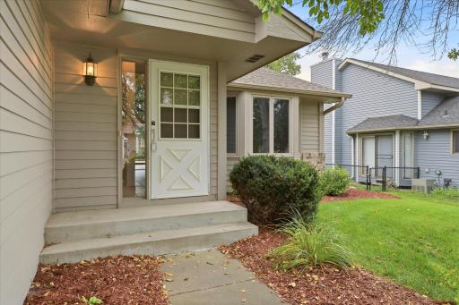 Welcoming front entry surrounded by professional landscaping, creating a polished and inviting approach to the home.