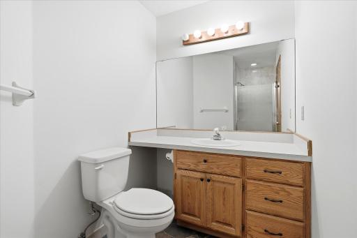 Private primary ¾ bath features a walk-in shower, vanity storage, and a bright, well-maintained finish.