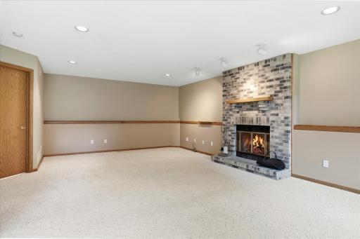 Spacious lower-level family room is designed for both relaxing and entertaining, featuring built-in surround sound, recessed lighting, and a continuous display ledge that wraps around the room.