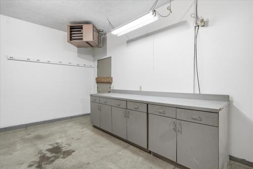 This impressive garage is more than just parking, featuring a workbench, hot and cold water, pull-down attic access for additional storage, 200-amp electrical service, and a 220V outlet, a fantastic setup for a workshop or hobby space.