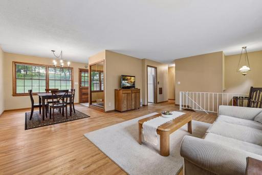 A wider view highlights the open flow between the spacious living and dining areas, with the kitchen just beyond.