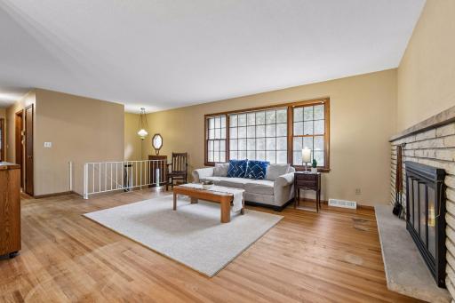 A large front window brings abundant natural light into the living room and highlights the original red oak hardwood floors.