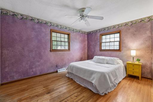 The spacious 13'10" x 10'4" primary bedroom features original red oak hardwood floors, two windows and plenty of room for a larger bedroom set.