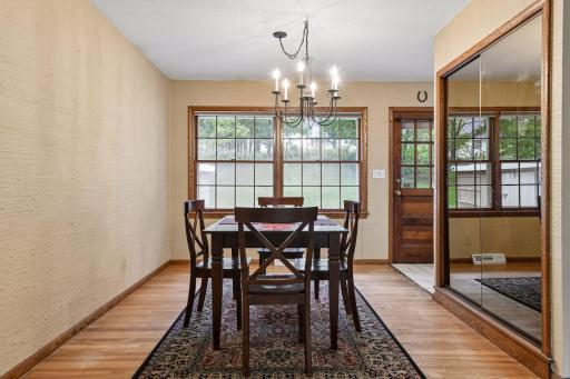 The open dining area continues the original red oak hardwood floors, with a large window overlooking the backyard and convenient access to the brick patio.