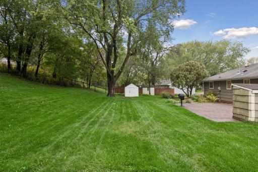 The expansive backyard offers plenty of room to enjoy the outdoors, with mature trees, a brick patio and lots of green space.