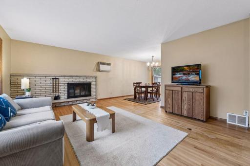 Original red oak hardwood floors and a beautiful brick fireplace add warmth and character to the spacious, open living and dining areas.