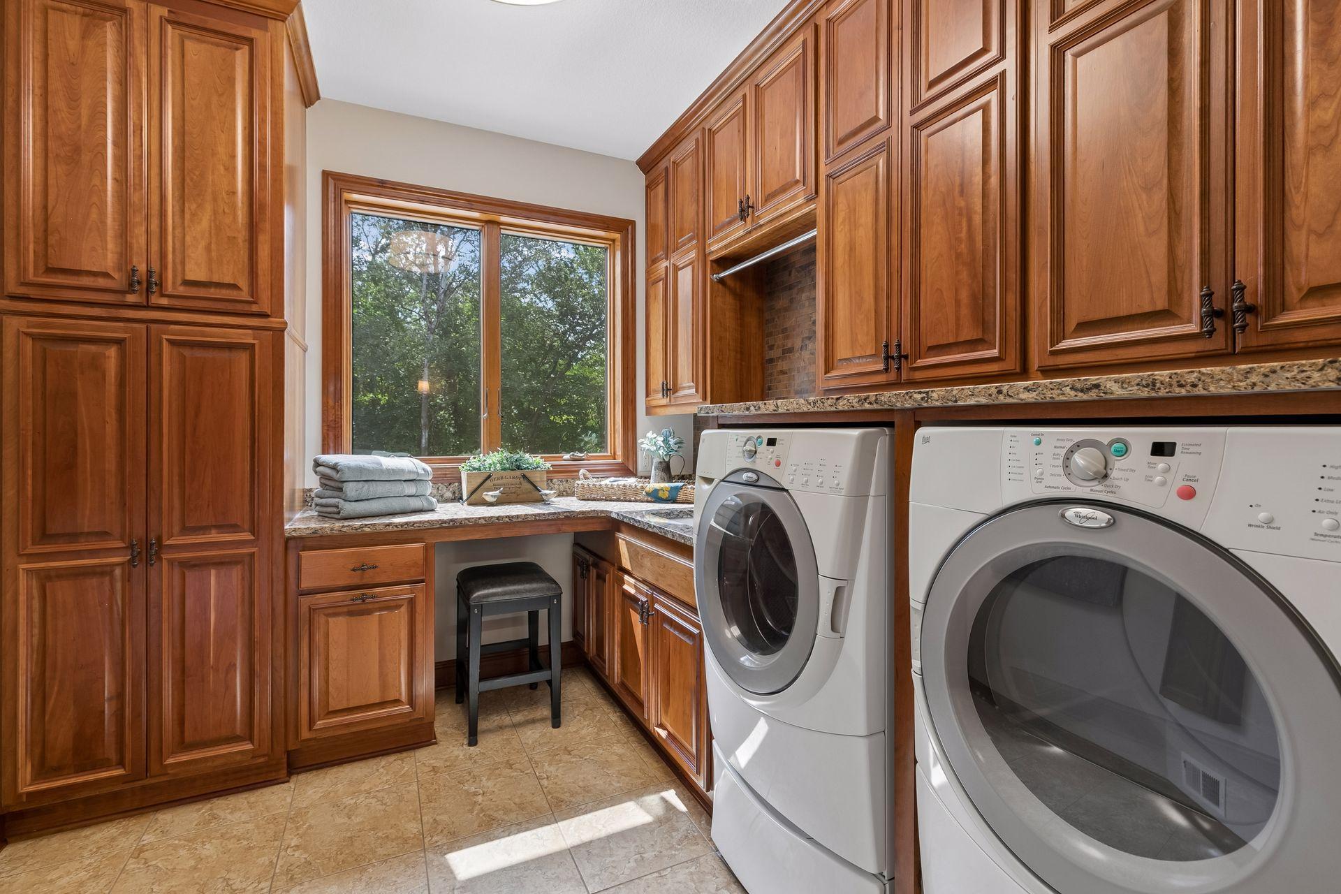 Large laundry room on main level with a sink and plenty of cabinets and a built-in ironing board