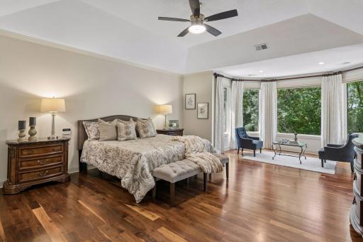 Luxurious primary suite with walnut floors and double-door entry