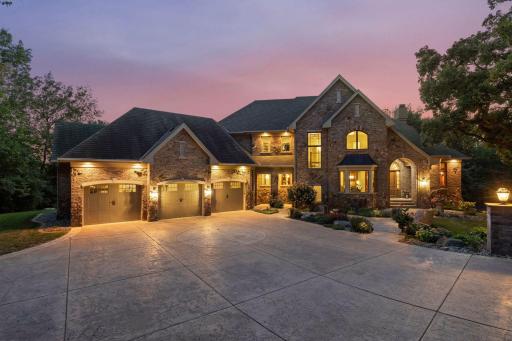 One-of-a-kind custom Wooddale built with an extended stamped concrete driveway