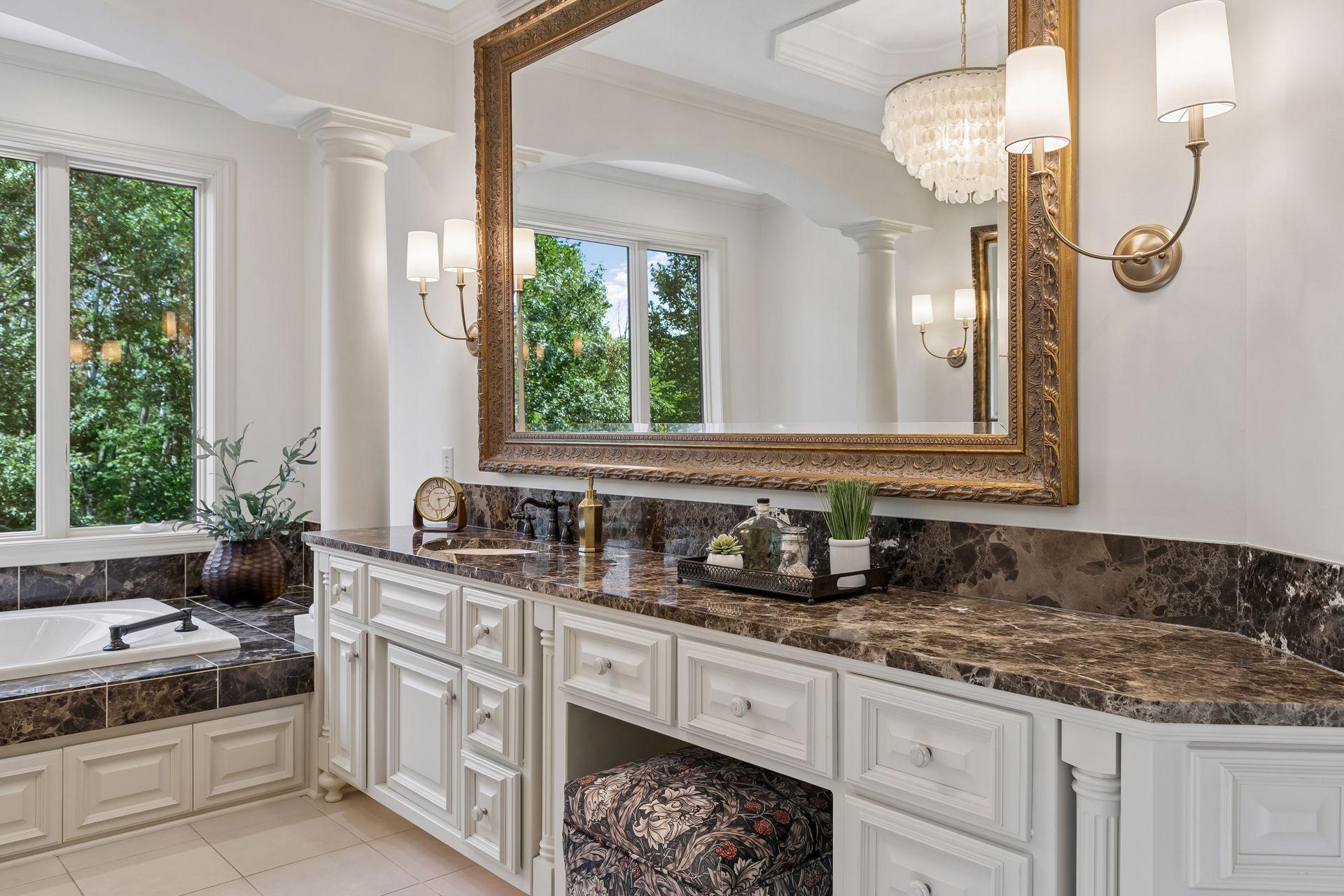 Dual granite vanities with an abundance of white enamel cabinetry with sitting area