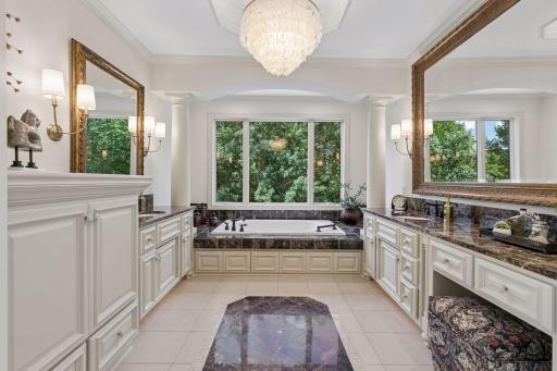 Spa inspired bathroom with custom heated floors, white enamel woodwork and stunning tier ceiling fixture