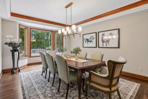 Formal dining room with pristine walnut floors, bay window and cove ceiling with lights
