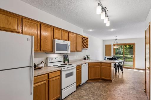 Kitchen with ample cabinetry, generous counter space, breakfast bar and open dining area.