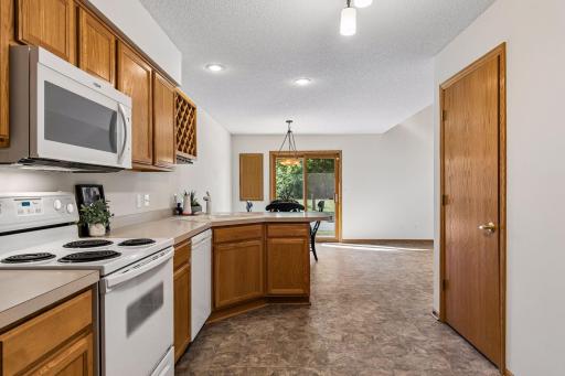 Functional kitchen layout with generous cabinet and counter space, breakfast bar and large utility room/storage closet at door to the right.