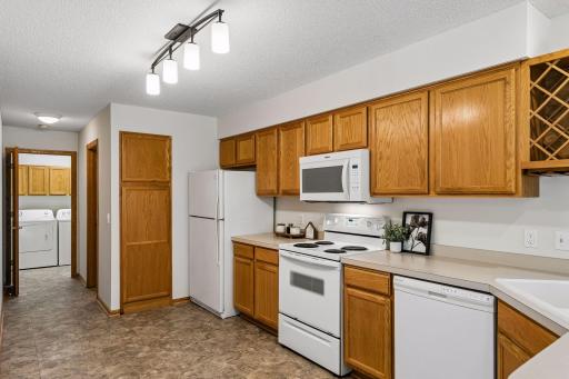 Kitchen offers abundant cabinetry and counter space, built-in wine storage and convenient access to the main-level laundry.