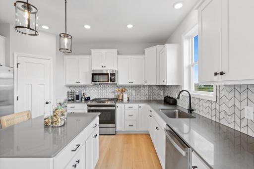 Kitchen layout - photo represents similar floorplan but not identical. Staged model in another community. Finishes and selections may vary. See listing realtors for details.