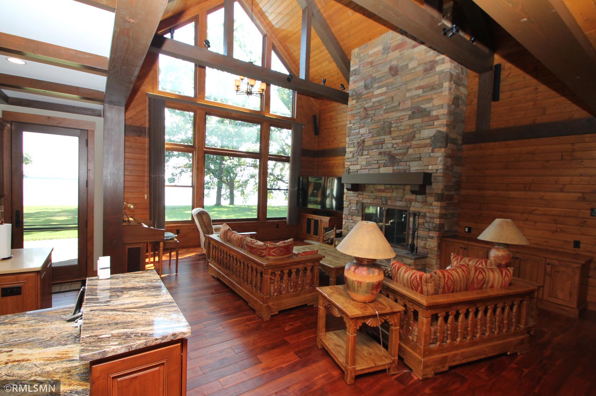 Living room with a wall of lakeside windows. Marvin Windows throughout the home.