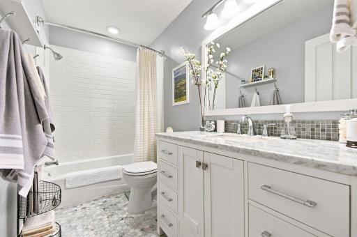 Remodeled upper-level full bath with Carrera marble and subway tile
