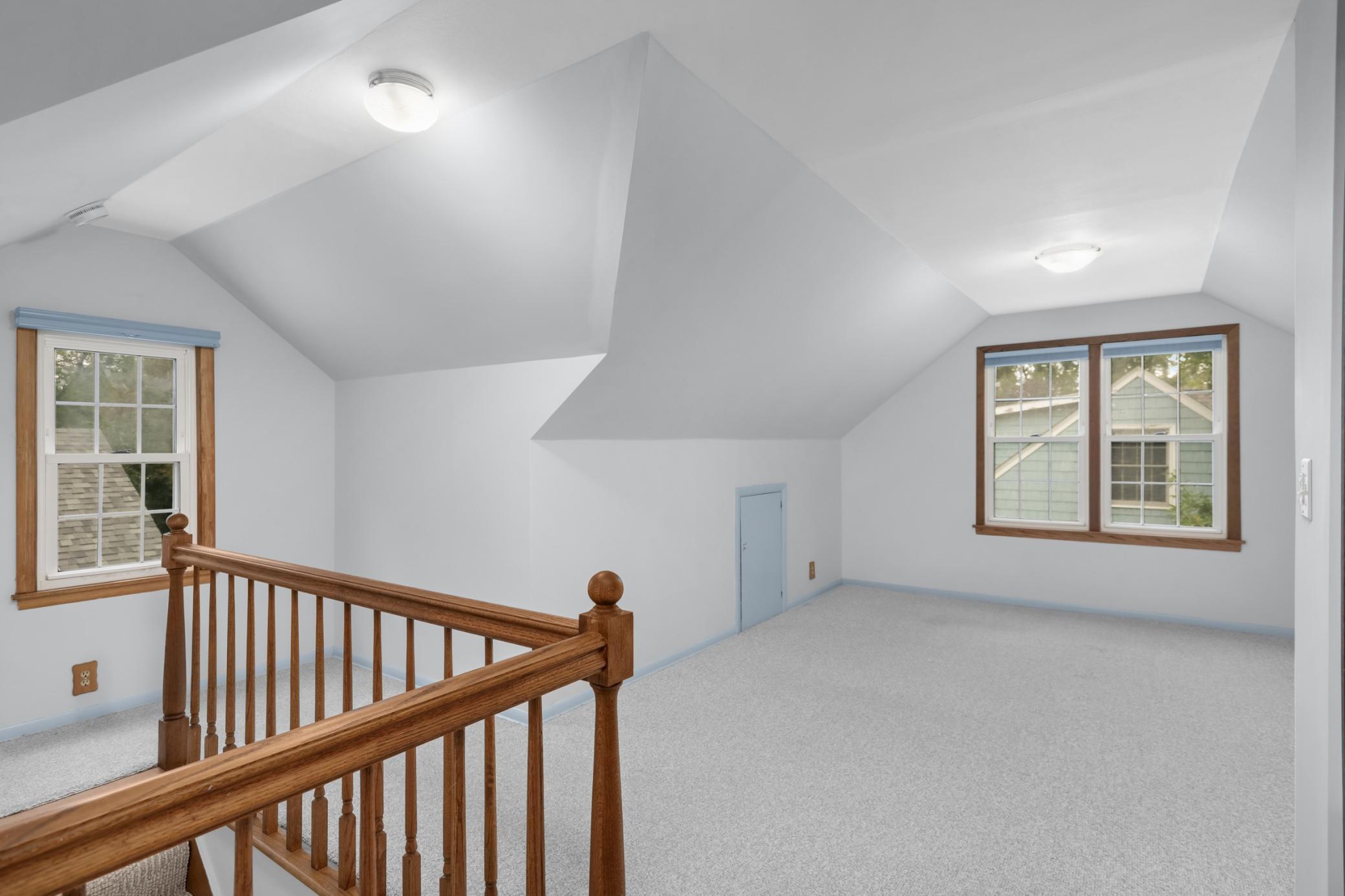 The upper level primary suite is spacious and light.