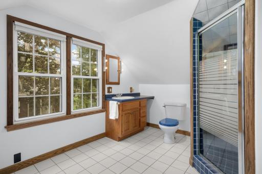 This spacious bathroom has a full ceramic tile shower, and enough space to double as a dressing room.