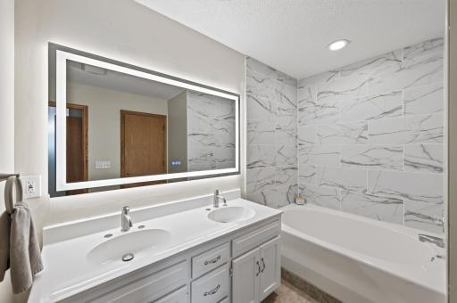 The upper level bathroom features a dual-sink vanity with an oversized mirror providing plenty of room to get ready.