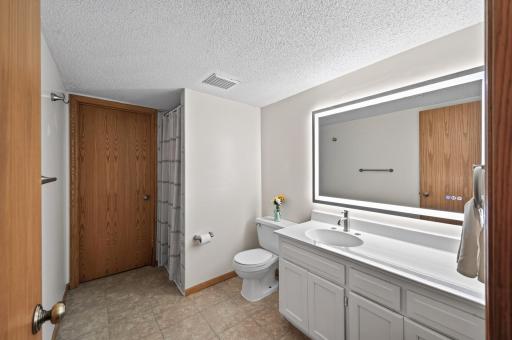 The additional bathroom adds everyday convenience to the lower level and features a spacious vanity with plenty of storage and beautifully tiled shower.