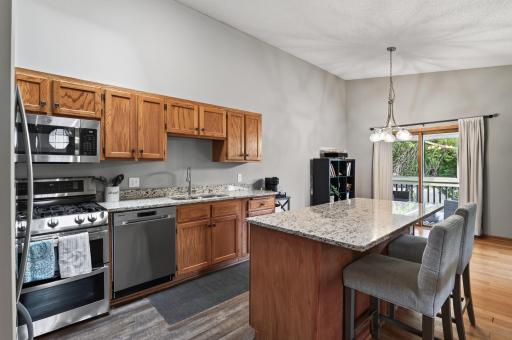 The kitchen features rich wood cabinetry, granite countertops, and stainless steel appliances.