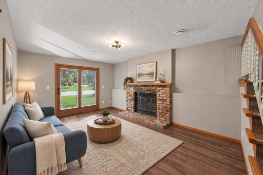 Image has been virtually staged. The walk-out lower level is centered around a wood-burning fireplace with classic brick surround.
