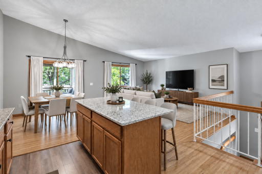 Image has been virtually staged. A large center island anchors the kitchen while the open layout creates an easy connection to the dining and living room.