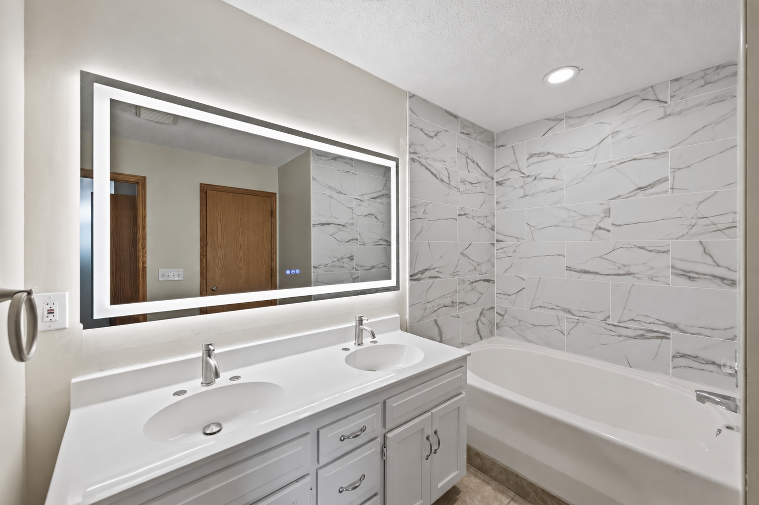 The upper level bathroom features a dual-sink vanity with an oversized mirror providing plenty of room to get ready.