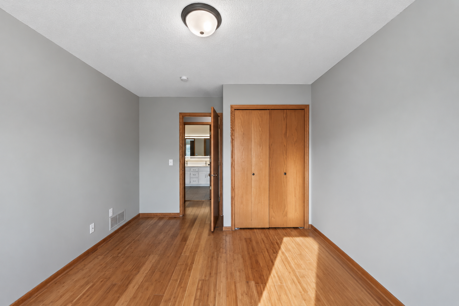 Bamboo flooring continues into the additional bedroom, creating a cohesive look throughout the upper level.