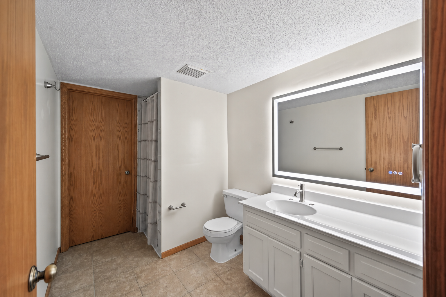 The additional bathroom adds everyday convenience to the lower level and features a spacious vanity with plenty of storage and beautifully tiled shower.