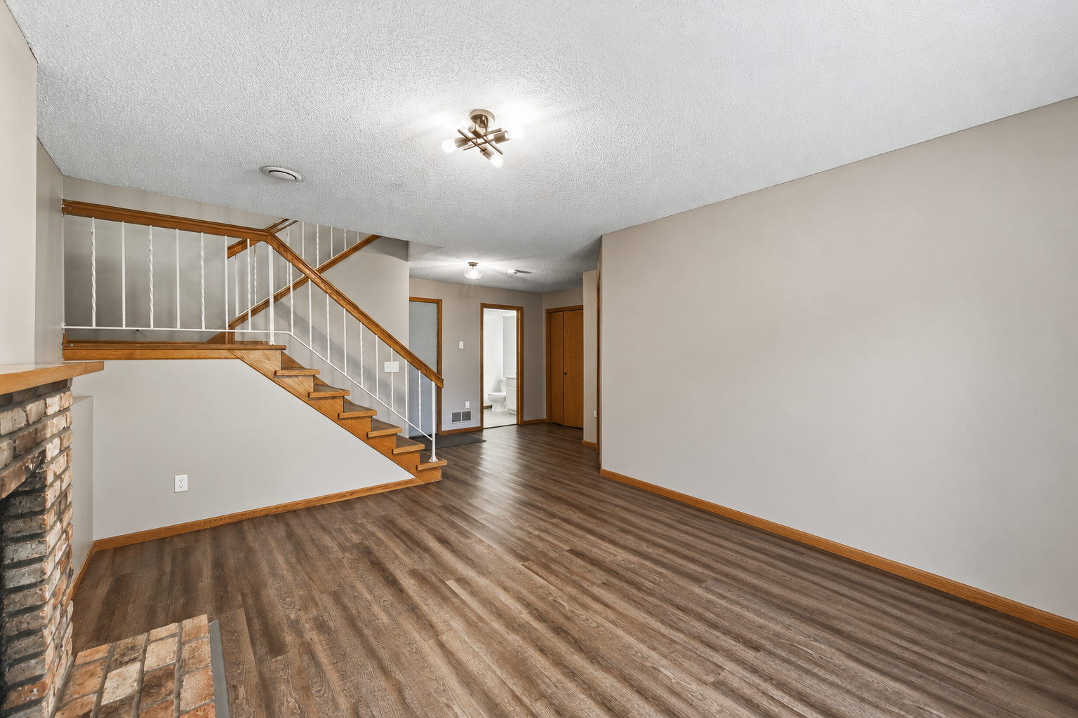 Fresh paint and LVP flooring give this roomy lower-level a refreshed feel, with convenient access to the outdoors.