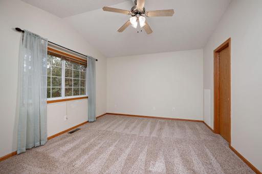 Primary suite offers vaulted ceilings, a ceiling fan, a large walk-in closet, a linen closet, and a walk-through full bathroom!