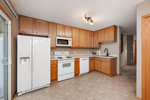 Kitchen with an eat-in dining space area and a sliding glass door leading to your private patio with mature trees!