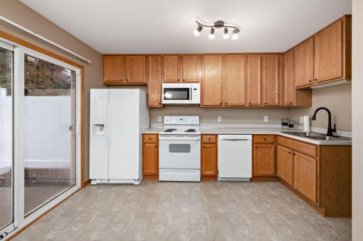 Kitchen with an eat-in dining space area and a sliding glass door leading to your private patio with mature trees!