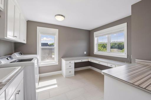 Stay organized with this enormous laundry room that features a sink, lots of cabinets, perfect for folding clothes, ironing or just enjoying your hobbies - sewing, craft....