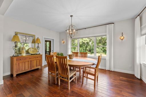 The kitchen flows seamlessly into the formal dining room, where large rear-facing windows fill the space with natural light.