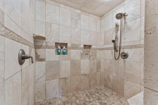 The spacious 6' x 6' walk-in tile shower, featuring dual shower heads.