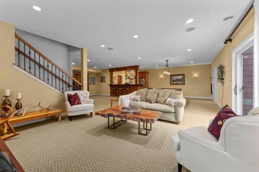 Another view from the family room showcasing the open-concept lower level, with views into the nearby recreation room and wet bar area.