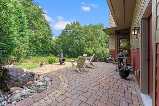 The backyard is equally impressive, offering multiple spacious patio areas, a charming chiminea, and access to an incredible three-season porch featuring a cozy wood-burning fireplace.