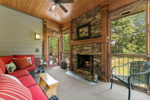 The porch features carpeting, a ceiling fan, a wood-burning fireplace, and direct access to the patio.